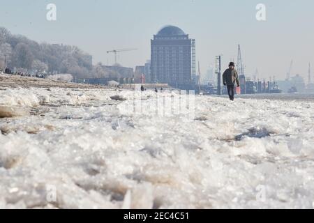 Hamburg, Deutschland. Februar 2021, 13th. Wanderer laufen über die eisigen Ufer der Elbe auf der Höhe von Strandperle. Quelle: Georg Wendt/dpa/Alamy Live News Stockfoto