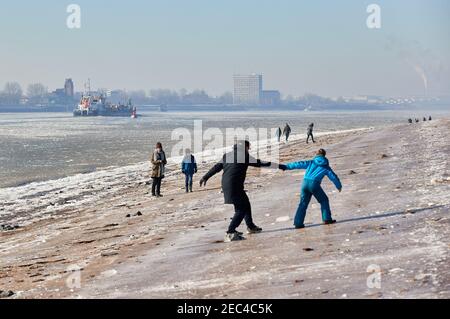 Hamburg, Deutschland. Februar 2021, 13th. Wanderer und Kinder laufen über die eisigen Ufer der Elbe auf der Höhe von Strandperle. Quelle: Georg Wendt/dpa/Alamy Live News Stockfoto