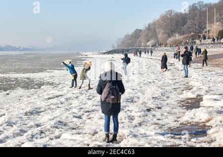 Hamburg, Deutschland. Februar 2021, 13th. Wanderer und Kinder laufen über die eisigen Ufer der Elbe auf der Höhe von Strandperle. Quelle: Georg Wendt/dpa/Alamy Live News Stockfoto