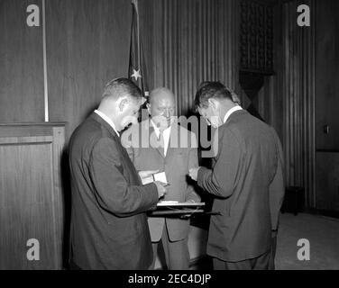 Generalstaatsanwalt Robert F. Kennedy (RFK) und Finanzminister C. Douglas Dillon bei einer Preisverleihung für den ehemaligen Kommissar für Narkotika, Harry J. Anslinger, Finanzministerium Gebäude. Generalstaatsanwalt Robert F. Kennedy nimmt an einer Preisverleihung zu Ehren des ehemaligen Kommissars für Betäubungsmittel, Harry J. Anslinger, Teil. Generalstaatsanwalt Kennedy (zurück zur Kamera) und Herr Anslinger (Mitte) schauen sich die Auszeichnung an; der Mann links ist nicht identifiziert. Treasury Department, Washington, D.C. Stockfoto