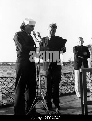 Präsident Kennedy beobachtet das 1st Americau0027s Cup Race. Präsident John F. Kennedy erhält ein Schiffsmodell des Zerstörers, USS Joseph P. Kennedy, Jr. (nicht abgebildet), als Geschenk von der Besatzung des Joseph P. Kennedy, Jr., während er das erste Rennen des 1962 Americau0027s Cup an Bord des Zerstörers besucht. Rechts steht der Untersekretär der Marine, Paul u0022Redu0022 Fay. Newport, Rhode Island. Stockfoto