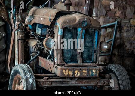 Ein altes Fordson Power Major, das zwischen 1958 gebaut wurde Und 1961 suchen traurig und vernachlässigt in einem alten Bauernhof Gebäude Stockfoto