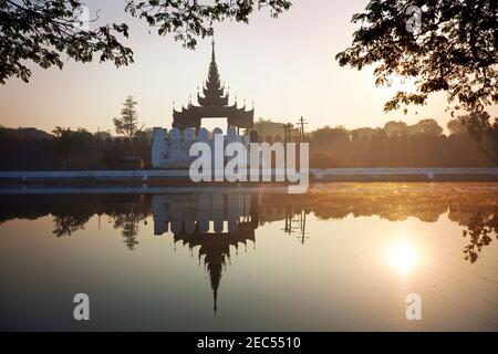 Alte braune Backstein Palastmauer mit Reflexion im Kanal rund um den Mandalay Palast in Mandalay, Burma (Myanmar) bei Sonnenaufgang Stockfoto