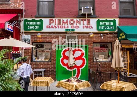 Das Zeichen des italienischen Restaurants Piemonte Ravioli in Little Italy, Manhattan und die Tische im Freien auf der Straße Stockfoto