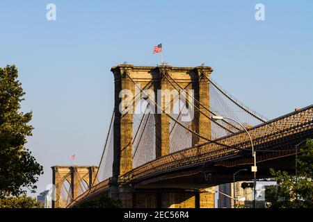 Eine Nahaufnahme der Brooklyn Bridge mit der amerikanischen Flagge Oben von der Frankfort Street in Manhattan aus gesehen Stockfoto