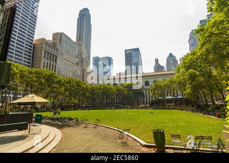 Leere Tische und Stühle im Bryant Park und New York Öffentliche Bibliothek Hauptzweig im Hintergrund auf einem Sommer Tag Stockfoto