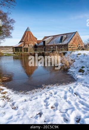 East Linton, East Lothian, Schottland, Großbritannien. Februar 2021, 13th. Historische Preston Mühle gesehen im Schnee an einem bitterkalten sonnigen Tag mit Temperatur von -2C. Kredit: Iain Masterton/Alamy Live Nachrichten Stockfoto