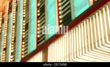 Defokussierte alte angefaste elektrische Lampen leuchten in der Nacht. Abstrakte Nahaufnahme von verschwommener Retro-Casino-Dekoration schimmernd, Las Vegas USA. Beleuchtetes vi Stockfoto