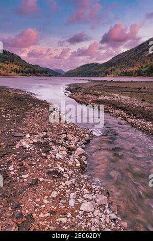 Rosa gefärbte Wolken, wenn die Sonne über dem Coniston-Wasser im Lake District National Park, Cumbria, England, Großbritannien untergeht Stockfoto