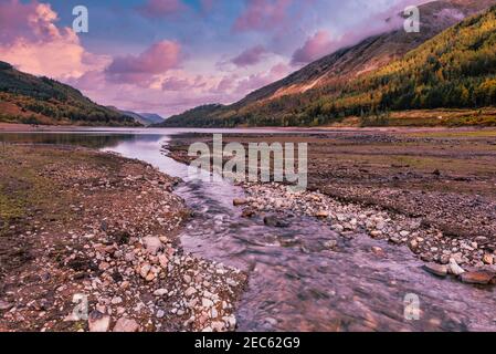 Rosa gefärbte Wolken, wenn die Sonne über dem Coniston-Wasser im Lake District National Park, Cumbria, England, Großbritannien untergeht Stockfoto