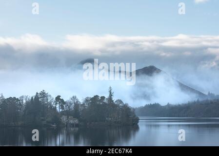 Episches Landschaftsbild mit Blick über Derwentwater im Lake District Catbells schneebedeckter Berg mit dichtem Nebel Rollen durch Tal Stockfoto