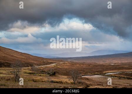 Atemberaubende Landschaftsaufnahme im Glencoe Valley in den schottischen Highlands Mit Bergketten in dramatischer Winterbeleuchtung Stockfoto