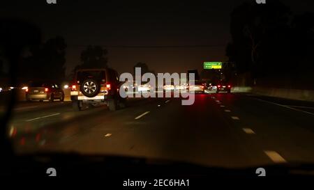 Blick aus dem Auto. Los Angeles belebte Autobahn bei Nacht. Massive Interstate Highway Road in Kalifornien, USA. Schnelles Auto auf Expressway-Fahrspuren. Stockfoto