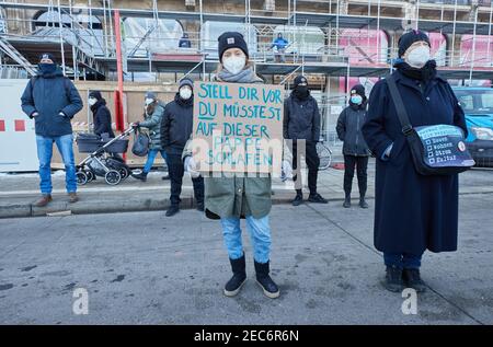 Hamburg, Deutschland. Februar 2021, 13th. Ein Teilnehmer hält während einer Demonstration auf dem Jungfernstieg ein Transparent mit der Aufschrift "Stellen Sie sich vor, Sie müssten auf diesem Karton schlafen". Mehr als 200 Menschen demonstrierten für die Unterbringung von Obdachlosen in Hotels. Quelle: Georg Wendt/dpa/Alamy Live News Stockfoto