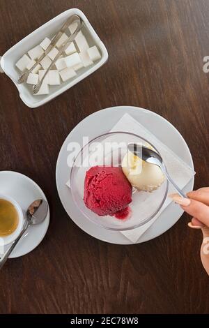 Rote und weiße Kugel Eis. Espresso-Kaffeetasse und Zuckerdose mit Zucker Stockfoto
