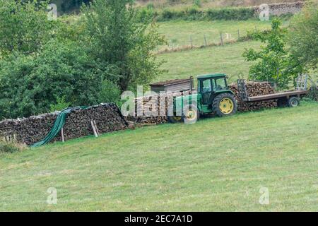 Linie von Brennholz mit Traktor auf Landschaft mit grünen Bäumen im Herbst Landschaft von Bourgogne, Frankreich Stockfoto