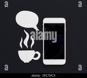 Weißes Telefon und leere Text Blase und heiße Getränke Tasse. Frühstück mit Smartphone flach Lay Foto. Sprechen Handy Banner Vorlage mit Text Platz. Bla Stockfoto