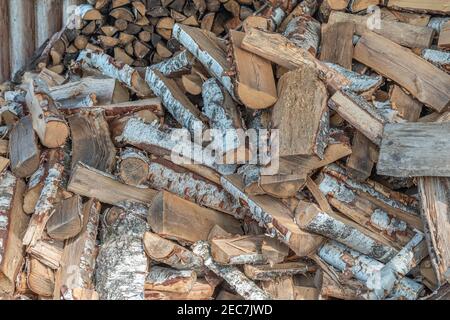 Natürlicher organischer Holzhintergrund. Brennholz gestapelt und für die Wintersaison vorbereitet. Nahaufnahme von gehacktem Brennholz. Stockfoto