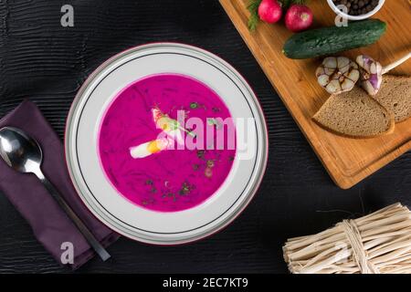 Rosafarbene Creme-Suppe aus Rote Bete, mit Ei, gehackter Gurke und Fenchel, kalt auf weißem Teller serviert Stockfoto