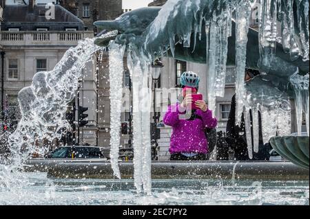 London, Großbritannien. Februar 2021, 13th. Als der Sturm Darcy verblasst und das Eis zu schmelzen beginnt, kommen die Menschen heraus, um das letzte Eis auf den Statuen auf dem Trafalgar Square zu sehen. Besucher treffen sich mit Freunden und/oder trainieren. Outdoor-Leben im Zentrum von London in Lockdown 3. Kredit: Guy Bell/Alamy Live Nachrichten Stockfoto