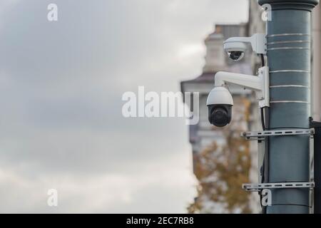 Ansicht einer modernen CCTV-Überwachungskamera, die an einem Metallmast befestigt ist. 360 Grad Sicherheitsvideokamera in der City Street auf klassischem Gebäude in der Stadt zurück Stockfoto
