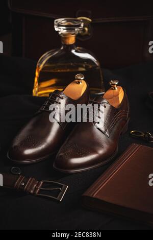 Stylische Herrenschuhe, Gürtel und Tagebuch auf schwarzem Hintergrund Stockfoto