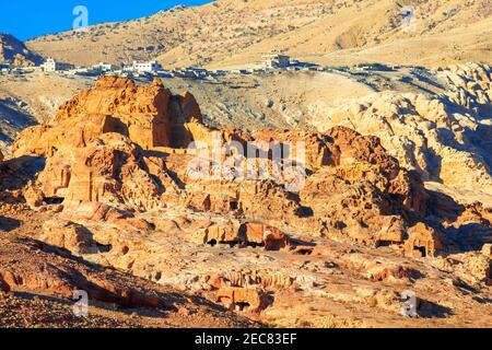 Ruine von Moghar Annassara (christliche Gräber) in Petra und Uum Sayhoun Dorf im Hintergrund, Jordanien. Petra Luftaufnahme Perspektive der alten Höhlen Stockfoto