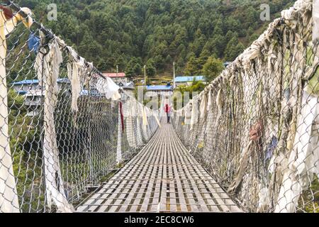 Brücke über den Fluss, Solo-Trekker auf der Hängebrücke in Nepal, Trekking im Himalaya, Everest Base Camp, Annapurna Circle Stockfoto