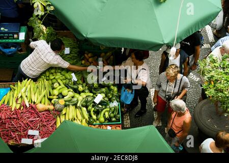 Funchal, Madeira, Portugal - September 2017: Blick von oben auf einen Stallhalter im Farmers' Marker, der einen Verkauf von Gemüse an einen Kunden macht Stockfoto