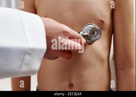Kinderarzt hört einem Patienten mit Stethoskop zu. Auskultation von Lunge und Herz in der pädiatrischen Praxis und regelmäßiges Chek-up-Konzept. Nahaufnahme Stockfoto