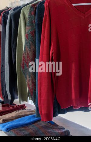 Vertikale Aufnahme einer Gruppe von Herren Pullover auf Kleiderbügel und unten gefaltet. Stockfoto