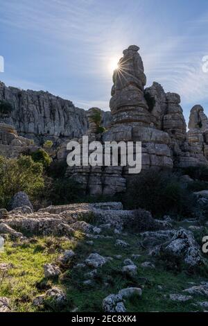 Landschaft mit Abendlicht mit einem Sonnenstern im El Torcal Naturschutzgebiet in Andalusien mit seltsamen Karstfelsen Formationen Stockfoto