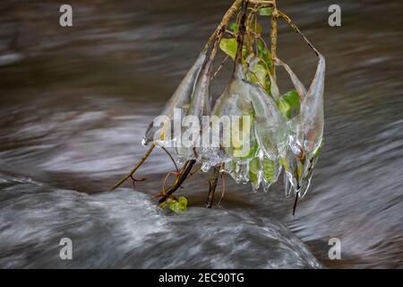 Große und ungewöhnliche Eisformationen, die über dem tobenden Wasser baumeln Stockfoto