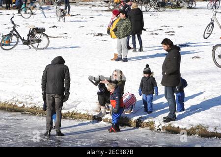 Amsterdam, Niederlande. Februar 2021, 13th. Am 13. Februar 2021 in Amsterdam, Niederlande, genießen die Menschen den gefrorenen Kanal im Rembrandt Park. Der niederländische Ministerpräsident Mark Rutter fragte die Menschen während der Pressekonferenz am vergangenen Freitag nicht brechen die Maßnahmen gegen Covid-19 auch auf dem Eis, das Virus ist nicht weniger infektiös auf Eis. (Paulo Amorim/Sipa USA) Quelle: SIPA USA/Alamy Live News Stockfoto