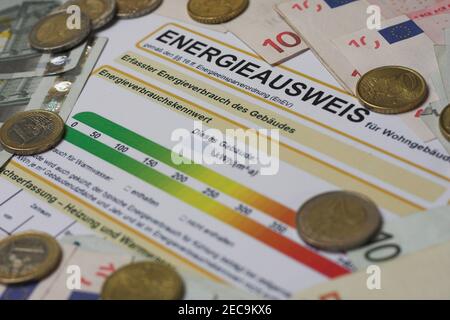 Formular Energiezertifikat für einen Nachweis der Energieeffizienz in deutscher Energieausweis mit Euro-Scheinen und Münzen Stockfoto