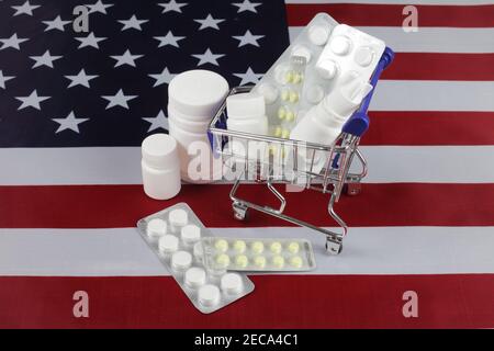 Pillen, Drogen in einem Supermarkt-Warenkorb auf der Unschärfe US-Flagge. Stockfoto