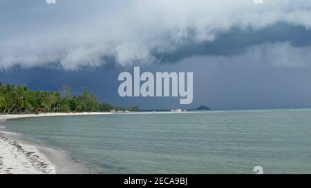 Winkendes blaues Meer, sandige Küste von Samui Island während der Regenzeit, Thailand. Hurrikan und Sturmwarnung am exotischen tropischen Ozeanstrand. Schneller Wind A Stockfoto