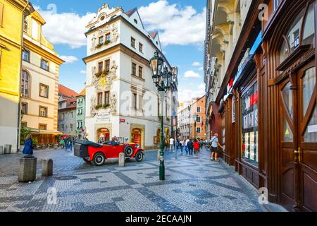 Malerische Aussicht auf einen touristischen Teil der Altstadt von Prag, Tschechien, mit Oldtimer, gepflasterten Straßen und malerischen Geschäften und Hotels Stockfoto