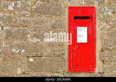 Ein roter britischer Briefkasten oder Briefkasten in einer Wand am Stadtrand von Arbroath, Schottland. Es trägt die Chiffre von George V (1910-1936). Stockfoto