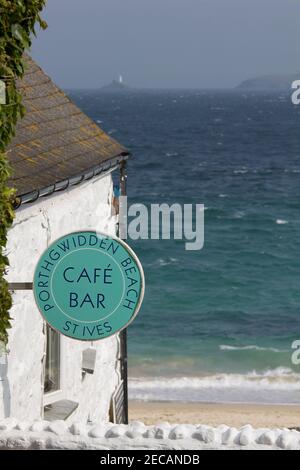 Porthgwidden Café mit Blick auf Porthgwidden Beach in St. Ives, Cornwall. Der Leuchtturm von Godrevy am Godrevy Point in der Ferne über die Bucht. Stockfoto