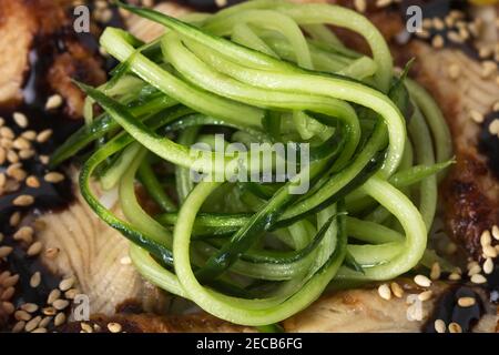 Fischfilets mit Gurkenscheiben und Omelette im asiatischen Stil. Makro. Foto kann als ganzer Hintergrund verwendet werden. Stockfoto