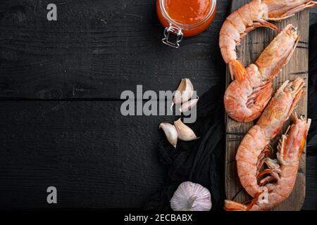 Rohe Garnelen mit Knoblauch, Limette, Mango-Sauce und Curry für Grill-Set, auf Holzschneidebrett, auf schwarzem Holztisch Hintergrund, Draufsicht flach legen, wi Stockfoto