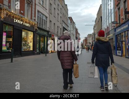 Zwei Frauen gehen während der COVID-19 Pandemiesperre in einer leeren und menschenleeren Grafton Street im Stadtzentrum von Dublin.die Sperrbeschränkungen der Stufe 5 sollen von der irischen Regierung verlängert werden. Um mindestens sechs weitere Wochen, in denen nur Schulen und der Bausektor voraussichtlich noch vor Ostern wieder eröffnet werden dürfen. Stockfoto