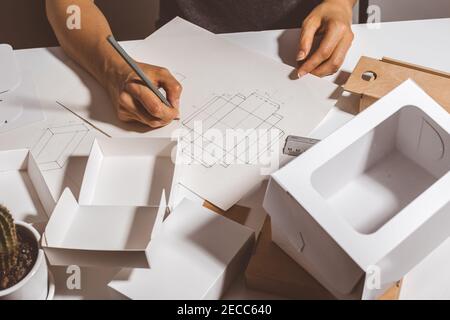 Designer zeichnet ein Modell für die Herstellung von Öko-Karton. Stockfoto