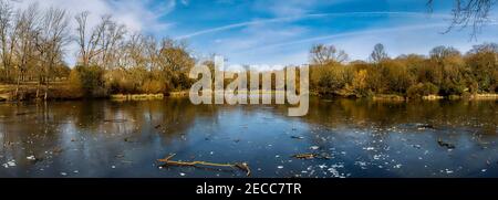 Ein schönes gefrorenes Hampstead Nummer 2 Teich Winterlandschaft Panorama mit blauem Himmel und einem eisigen See. Hampstead Heath, London, Großbritannien. Stockfoto