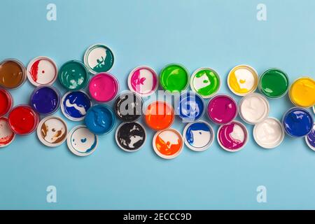 Auf dem Tisch sind Acrylfarben verschiedener Farben zum Zeichnen geöffnet. Helle bunte Hintergrund aus Farbdosen Stockfoto