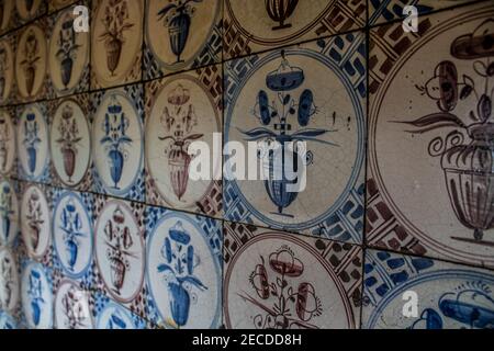 Delfter blauer Blumentopf an der Wand hinter offenem Feuer Stockfoto