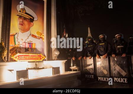 Neben einem Porträt des thailändischen Königs Maha Vajiralongkorn (Rama X) vor dem Königlichen Großen Palast stehen während der Demonstration Polizeibeamte mit Gesichtsmasken auf Wache. Demonstranten versammeln sich am Democracy Monument, bevor sie zum Bangkok City Pillar Shrine in der Nähe des Königlichen Großen Palastes marschieren, um die Reform der Monarchie zu fordern und das Gesetz der Majestät abzuschaffen (Artikel 112 des thailändischen Strafgesetzbuches) und 4 Aktivisten freizulassen (Somyot Pruksakasemsuk, Patiwat Saraiyam, Parit 'Penguin' Chivarak und Anon Nampa) Die vom Gesetz über die majesteste lese (Artikel 112) verhaftet wurden. Stockfoto