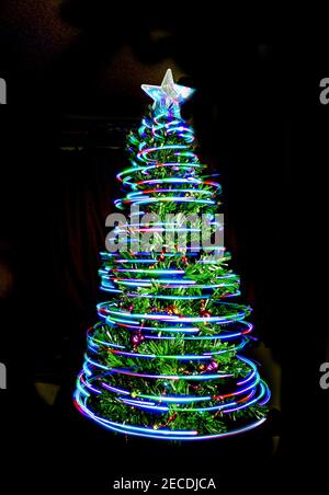 Weihnachtsbaum mit Lichtern umwickelt und Stern auf der Oberseite Stockfoto