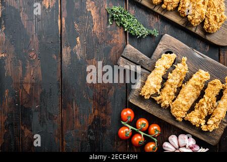 Hausgemachte knusprig gebratene Hühnerteile auf alten dunklen Holztisch, Draufsicht, mit Kopieplatz. Stockfoto